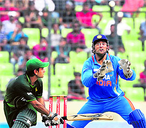 MS Dhoni (R) tries to catch the ball as Pakistan�s Mohd Hafeez plays a shot during their crucial Asia Cup ODI at the Sher-e-Bangla National Stadium in Dhaka on Sunday. India won the match by six wickets in what is their highest run chase in ODIs