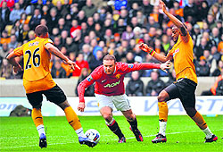 Wolverhampton Wanderers' David Davis (L) and Sebastien Bassong (R) challenge Manchester United's Wayne Rooney in Wolverhampton on Sunday
