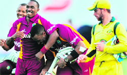 West Indies� Carlton Baugh (L), Dwayne Bravo (C) and Kieron Pollard celebrate their victory as Australian wicketkeeper Matthew Wade (R) looks on in Kingstown