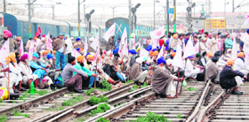 Members of the Kisan Sangharsh Committee squat on railway tracks at the Amritsar railway station on Tuesday.