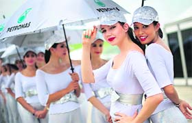 Grid girls pose in the paddock area during the qualifying session of the Malaysian GP
