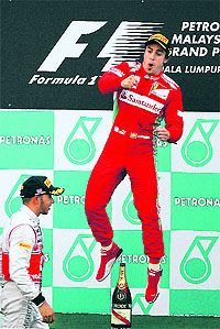 Ferrari Formula One driver Fernando Alonso of Spain celebrates on the podium after winning the Malaysian Formula One Grand Prix at Sepang on Sunday