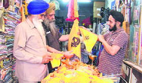 A shopkeeper shows flags to customers.