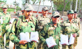 BSF jawans with the packets of heroin seized from Pakistani smugglers in Attari sector near Amritsar on Monday.