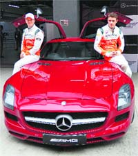 Sahara Force India drivers Nico H�lkenberg (L) and Paul di Resta with the Mercedes AMG car during an event at the Buddh International Circuit in Greater Noida on Tuesday