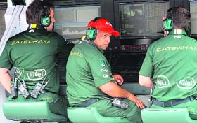 Caterham-Renault Formula One team Principal Tony Fernandes (C) monitors the drivers during the Malaysian Grand Prix
