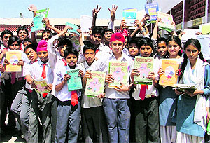 A file photo of students in new uniforms cheering after receiving free books under the Sarva Shiksha Abhiyan at PAU Government School, Ludhiana