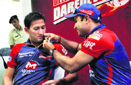 Delhi Daredevils� captain Virender Sehwag pins a blue ribbon on Ajit Agarkar�s jersey during a Unicef event, at the Ferozshah Kotla Stadium, in New Delhi on Friday. 