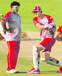 Kings XI Punjab�s Ramesh Powar (L) with captain-cum-coach Adam Gilchrist during a training session at the PCA Stadium, Mohali, on Friday.