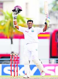 West Indies' Shivnarine Chanderpaul raises his bat after scoring a century during the second day of the first Test against Australia in Bridgetown on Sunday