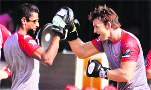 Kings XI Punjab captain Adam Gilchrist (R) during a workout session with trainer Adrian Dias at the PCA Stadium on Tuesday. 