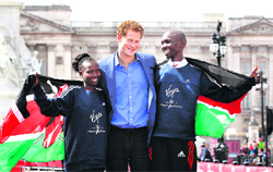 Britain�s Prince Harry poses with London Marathon winners Mary Keitany (left) and Wilson Kipsang, both from Kenya, outside Buckingham Palace in London. 