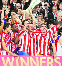 Atletico Madrid's players celebrate on the podium after  winning the UEFA Europa League final against Athletic Club Bilbao in Bucharest on Wednesday. 