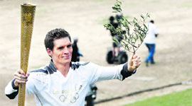 Greek Swimmer Spyros Gianniotis run with the Olympic flame.