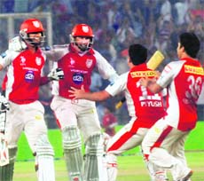 Kings XI players rush to greet their unbeaten batsmen Gurkeerat Singh (L) and David Hussey at the PCA Stadium in Mohali