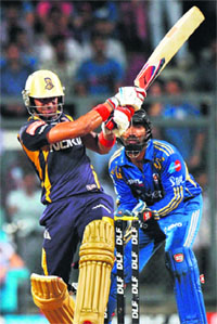 Kolkata Knight Riders� Manoj Tiwary (L) plays a shot as Mumbai Indians� wicketkeeper Dinesh Karthik looks on in Mumbai on Wednesday. 