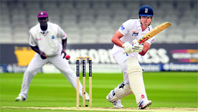 England�s Alastair Cook plays a shot as he�s watched by West Indies� captain Darren Sammy during the first Test at the Lord�s in London on Monday.
