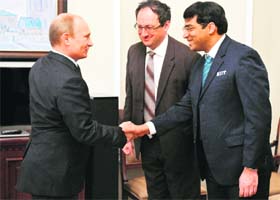 Russian President Vladimir Putin (L) shakes hands with Viswanathan Anand (R) as Boris Gelfand looks on during their meeting outside Moscow on Thursday