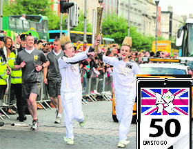 Olympics torch-bearers and Irish pop stars John and Edward Grimes, known as Jedward, carry the torch during their relay leg to the General Post Office in Dublin on Wednesday