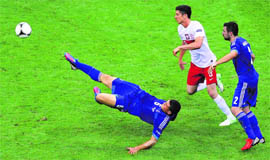 Poland's Robert Lewandowski (C) battles for the ball with Greece's Kyriakos Papadopoulos (L) and Giannis Maniatis during their match at the National Stadium in Warsaw on Friday. The match ended in a 1-1 draw. 