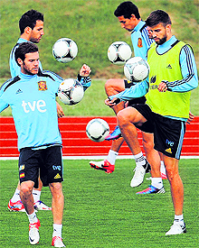 Spain�s Juan Mata (L) trains besides teammate Gerard Pique (R) during an evening session in Gniewino on Saturday. Defending champions Spain face Italy in their opening match on Sunday
