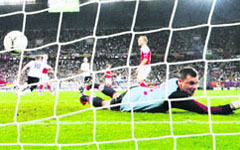 Danish goalkeeper Stephan Andersen fails to stop a strike by German forward Lukas Podolski (L) during their match at the Arena Lviv on Sunday. 