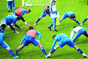 Greece�s coach Fernando Santos (C) walks as his players stretch during a training session at the Municipal Stadium in Legionowo. Greece face Germany in the quarterfinals on Friday