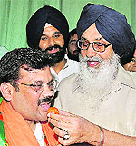 Chief Minister Parkash Singh Badal offers sweets to his newly appointed political adviser Kamal Sharma at the Punjab Secretariat