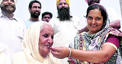 Surjit Singh�s wife Harbans Kaur and her daughter-in-law celebrate news of his release with laddoos