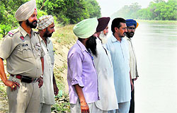 A police official and villagers at the crime spot