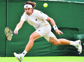 David Ferrer hits a return to Juan Martin del Potro during their match at The Wimbledon in London on Tuesday.