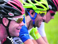 Defending champion Cadel Evans of Australia (L) has a laugh with two fellow riders during the fourth stage of Tour de France in north France on Wednesday