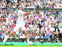Roger Federer of Switzerland returns to Mikhail Youzhny of Russia during their quarterfinal match at Wimbledon in London on Wednesday