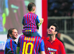 Spanish Euro 2012 champion Cesc Fabregas (R) greets the son of his fan Donna Agnesia (L) during a promotional event in Jakarta on Thursday. Agnesia spent $2,247 for the shoes of Fabregas in an auction during the event.
