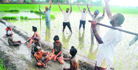 Farmers enjoy pre-monsoon showers at Baran village in Patiala district on Friday.