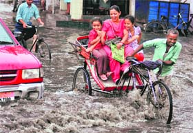 A family finds fun in the middle of a waterlogged road near Damoria Pul as rain lashed Ludhiana on Saturday
