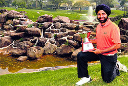 A handout photo from the Asian Development Tour shows Sujjan Singh posing with the trophy after winning the Taman Dayu Championship at the Taman Dayu Golf Club and Resort in Surabaya on Saturday