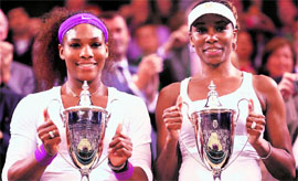 Serena and Venus Williams with their trophies after defeating Andrea Hlavackova and Lucie Hradecka, both of the Czech Republic, in their women's doubles final.