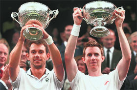Jonathan Marray of Britain (R) and his partner Frederik Nielsen of Denmark hold their trophies after winning the men�s doubles title.