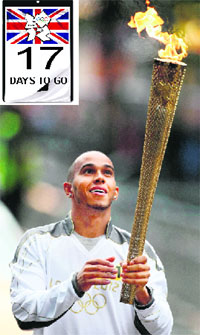 A handout image by LOCOG shows F1 driver Lewis Hamilton holding the Olympic Flame before his Torch Relay leg through Luton on Monday.