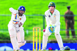 Sri Lanka�s Thisara Perera plays a shot as Pakistani wicketkeeper Taufeeq Umar looks on during the third day of the third Test in Pallekele on Tuesday.  