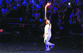 Britain's Steve Redgrave, a former rower, runs into the stadium with the torch.