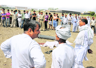 People gather around the dead body of Bajinder, a Class XII student allegedly murdered by his friends at Bastara village in Karnal