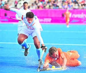 Netherland's Bob de Voogd (R) falls to the ground as he vies with VR Raghunath (L) during their match on Monday. The match ended 3-2 to the Netherlands.