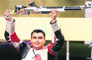 Gagan Narang lifts his rifle in celebration after winning bronze.