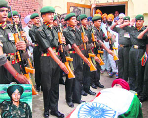 Army personnel pay tributes to Sepoy Sandeep Singh (inset) at Mangewal village in Patiala on Friday. 