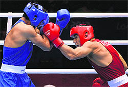 Vijender Singh (Left) takes a punch from Abbos Atoev on Monday night