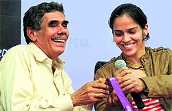 Saina Nehwal shows the Olympic bronze medal to her father prior to a press conference in Hyderabad on Tuesday