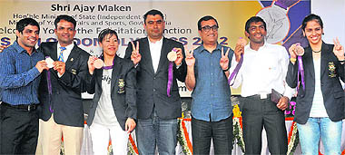 London Olympic medal winners (from L to R) Sushil Kumar, Vijay Kumar, Mary Kom, Gagan Narang, sports minister Ajay Maken, Yogeshwar Dutt and Saina Nehwal show their medals during a felicitation function at the Dhyan Chand National Stadium, New Delhi, on Thursday
