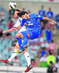 Real Madrid's Xabi Alonso and Getafe's Angel Lafita clash for the ball during their Spanish first division match in Getafe, near Madrid, on Sunday